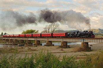 Locomotiva a vapor NZR JA classe 1271 cruzando o rio Otaki ao retornar de uma viagem a Woodville, Nova Zelândia. (definição 2 918 × 1 937)