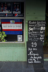 Billboard in front of a grocery store announcing "Gnocchi del 29" in the Soriano Department, Uruguay La ciudad se prepara para el festejo (13146686563).jpg