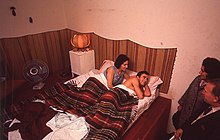 Visitors interact with a couple in bed, inside one of the many environments of La Menesunda (1965), one of the earliest large-scale installations in art history. La pareja en La Menesunda 1965.jpg