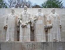 Central group of the Reformation Wall in Geneva, commemorating the founding fathers of Calvinism: William Farel, John Calvin, Theodore Beza, and John Knox. Le Mur des reformateurs (Geneve, Suisse) (26709884149).jpg