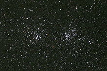 na obrázku malý výřez temné noční oblohy hustě poseté hvězdami, které tvoří dvě vedle sebe ležící hvězdokupy, z nichž ta vpravo je o trochu více zhuštěná