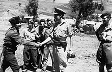 Xhelal Staravecka shaking hands with Major Billy McLean at Shtylla, August 1943 during the first SOE mission to Albania. Behind them are Stilian and Stephan and, on the right, Major Peter Kemp. Service of Major David Smiley With the Special Operations Executive (soe) in Albania, 1943 - 1944. HU65147.jpg