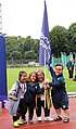 Handing over the flag of the Games from the German organizing committee to the Australian one (from left to right): Beck Kimwill, Samantha Lilly, Patricia Carl-Innig, Michael Spain. (2023)