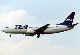 A white and blue Boeing 737 with 'TEA' written on its side and tail