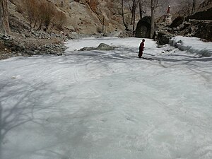 English: A monk ice skating on a frozen river.
