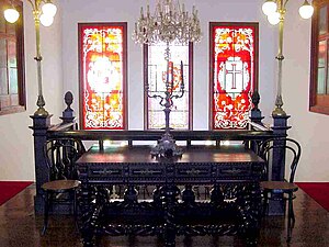 Furniture on the second floor landing, showing the stained-glass windows above the staircase