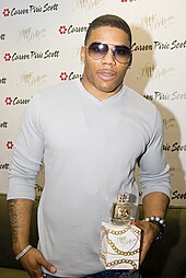 Nelly holding a bottle of perfume