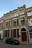Bankgebouw met woning in 'Um 1800' stijl. Het gebouw staat in een gesloten straatwand van de Groenmarkt, met de achtergevel aan de Voorstraatshaven
