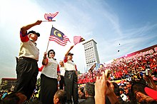 Najib and his wife Rosmah waving flags during the Malaysia Day celebration in Kuala Lumpur, 16 September 2011 Hari Malaysia celebration in 2011.jpg