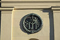 Eines der vier Medaillons mit einer Königskrone und den Initialen „MJ“ an den Säulen des Tors. „MJ“ steht für die Initialen des Königs von Bayern, Maximilian I. Joseph