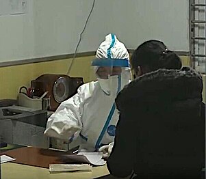 A doctor wearing special protective suit for the Wuhan coronavirus outbreak treats a patient in Hubei TCM Hospital, Wuhan, China