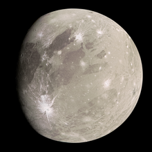 Cadrage sur Ganymède. Sa surface est grise foncée, avec une grande tache noire au nord et une grande tache blanche vers le sud.