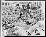 Two African American boys playing in vacant lot strewn with debris, W. 91st St., New York City