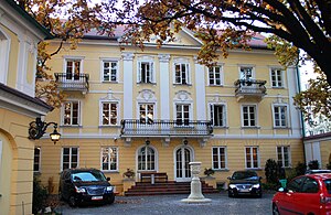 Die Fassade des dreigeschossigen Palastes mit großem Balkon im ersten Stock, Pilastern und Giebeldreieck