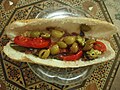 Sandwich filled with olives and sliced red tomatoes