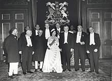 Kumpulan rasmi Elizabeth dalam tiara dan pakaian malam dengan sebelas ahli politik dalam pakaian malam atau pakaian kebangsaan.