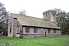 A small stone church with simple three-light windows and a west tower.