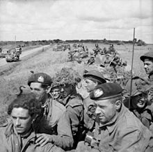 British infantry aboard Sherman tanks wait for the order to advance, near Argentan, 21 August 1944. The British Army in Normandy 1944 B9528.jpg