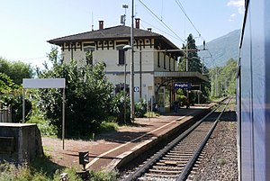 Two-story building with hip roof next to double-track railway line