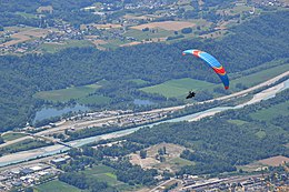Foto van parapenter boven verzorgingsplaats Aire de l'Arclusaz aan autosnelweg A43, Savoie, Frankrijk