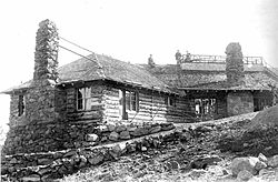 Historic photograph of a log building on a steep slope