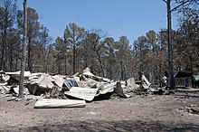 Photograph of a home reduced to charred rubble