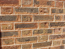 Tuckpointing: here red mortar is used. The white fillets are laid out at regular spacing, which does not always coincide with the rough spacing of the joints.