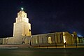 Vue nocturne du côté nord de la mosquée, montrant le minaret illuminé.