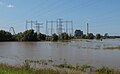 Weurt, el central eléctrica de carbón de energía con torres eléctricas y el puente (de Oversteek) durante las inundaciones en el Waal