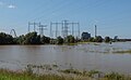 Weurt, energy coal-fired power station Engie with electricity pylons and bridge (the Oversteek) during high water in the Waal