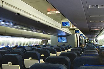 Основная кабина самолета с двумя проходами и несколькими рядами сидений.