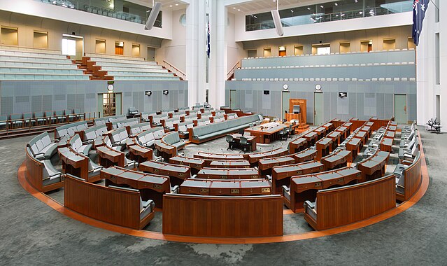 Vista da Câmara dos Representantes do Parlamento da Austrália em Camberra. A Câmara dos Representantes é a câmara baixa do Parlamento bicameral da Austrália, sendo a câmara alta o Senado. O mandato dos membros da Câmara dos Representantes é de no máximo três anos a partir da data da primeira sessão da Câmara, mas em apenas uma ocasião desde a Federação o mandato máximo foi atingido. A Câmara é quase sempre dissolvida antes, geralmente sozinha, mas às vezes em uma dissolução dupla com o Senado. As eleições para membros da Câmara dos Representantes são geralmente realizadas em conjunto com as eleições para o Senado. 
 (definição 4 202 × 2 500)