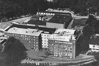 Flygbild över Barnängens område från 1950- eller 1960-talet. Barnängens tvålfabrik syns till höger med Barnängens skylt på hustaket och Vademecum-reklamen på gavelväggen. De övriga byggnaderna är rivna, utom huset närmast tvålfabriksbyggnaden.