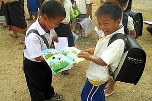 English: Two boys in Laos laugh over the book ...
