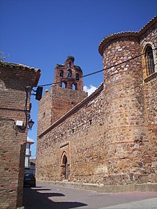 Vista trasera del campanario, la puerta sur y los torreones.