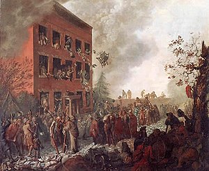 Burning three-story house, surrounded by a mob. People are throwing things out of the windows and belongings are scattered on the street.