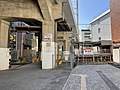 駅へ続く踏切と看板。高架に沿った手前側に新松戸駅出口がある。（2022年6月）