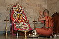 a Hindu priest with a glòt pitcher near his left knee, 2 March 2010.