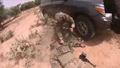 أحد الجنود الأمريكيين ملقى على الأرض، وأحد زملائه يحاول مساعدته.