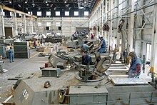 M1 Abrams tanks being refurbished at the Anniston Army Depot in 1989. Anniston Army Depot workers perform reset work on the turret of the M1 Abrams tank in 1989.jpg