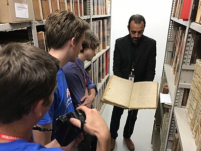 An archivist of Bibliothèque et Archives nationales du Québec (BAnQ) showing one of the oldest manuscripts of the judicial archives preserved at BAnQ during the 2017 Wikimania Pre-Conference
