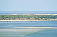 Une partie de la presqu’île du Cap-Ferret, avec son phare caractéristique, le bassin d’Arcachon au premier plan et l’océan Atlantique en arrière-plan.