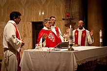 A contemporary Mass in modern practice, as versus populum became the common posture and gesture practised after the council. The priest faces the congregation, while vestments and artwork are less ornate. Clergy at Church of All Nations in Jerusalem -- 5 February 2011.jpg