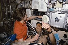 Dunbar uses a Doppler to collect medical data from payload specialist Lawrence J. DeLucas during his diagnostic "run" in the Lower Body Negative Pressure device (LBNP). The Doppler is used to pick up high-frequency sound waves from the surface of the heart, thus producing pictures on the monitor of the American Flight Echocardiograph (AFE). Crewmembers in the spacelab with the Lower Body Negative Pressure Study 2.jpg