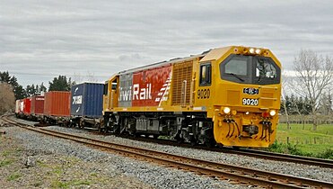 A DL class diesel locomotive leading a freight train, with KiwiRail branding