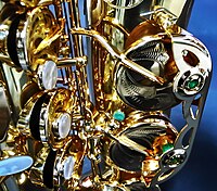The lower portion of a P. Mauriat alto saxophone, showing the mother of pearl key touches and engraved brass pad cups