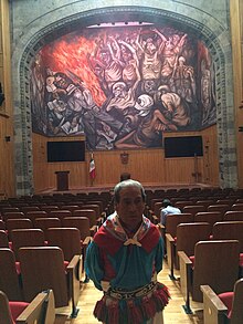 De la Torre in front of the mural "The people and their false leaders", by José Clemente Orozco.