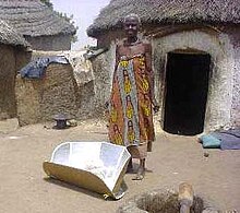 Solar cookers use sunlight as energy source for outdoor cooking. Solar-Panel-Cooker-in-front-of-hut.jpg