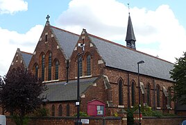 Iglesia de St Thomas (1888-1889), Islington, Londres, vista de la fachada occidental y de la nave lateral sur mostrando lancetas y el narthex de estilo inglés temprano debajo de las ventanas del oeste[CP 9]​