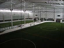 This picture is showing an indoor soccer arena with rebound boards surrounding it